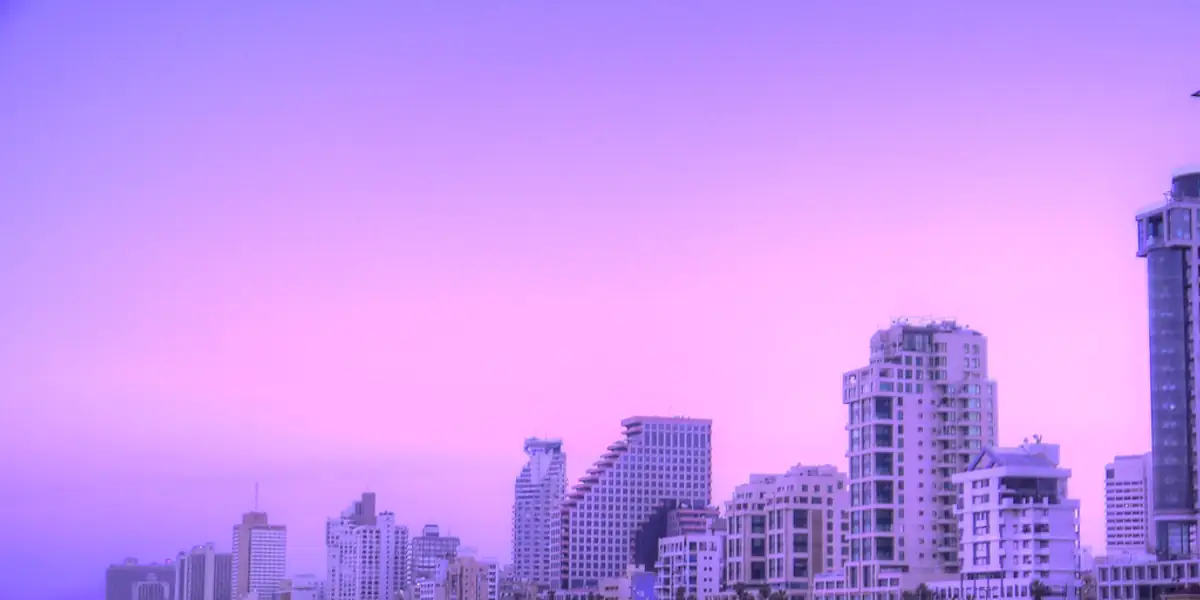 חוף תל אביב בשקיעה עם הטיילת והמגדלים ברקע